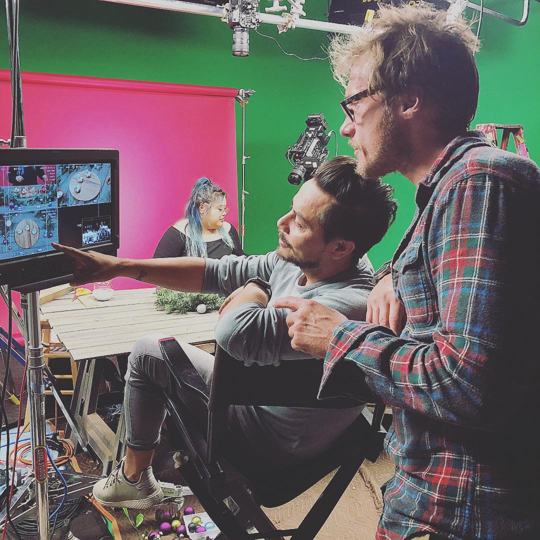 Director and DP reviewing playback on green screen set