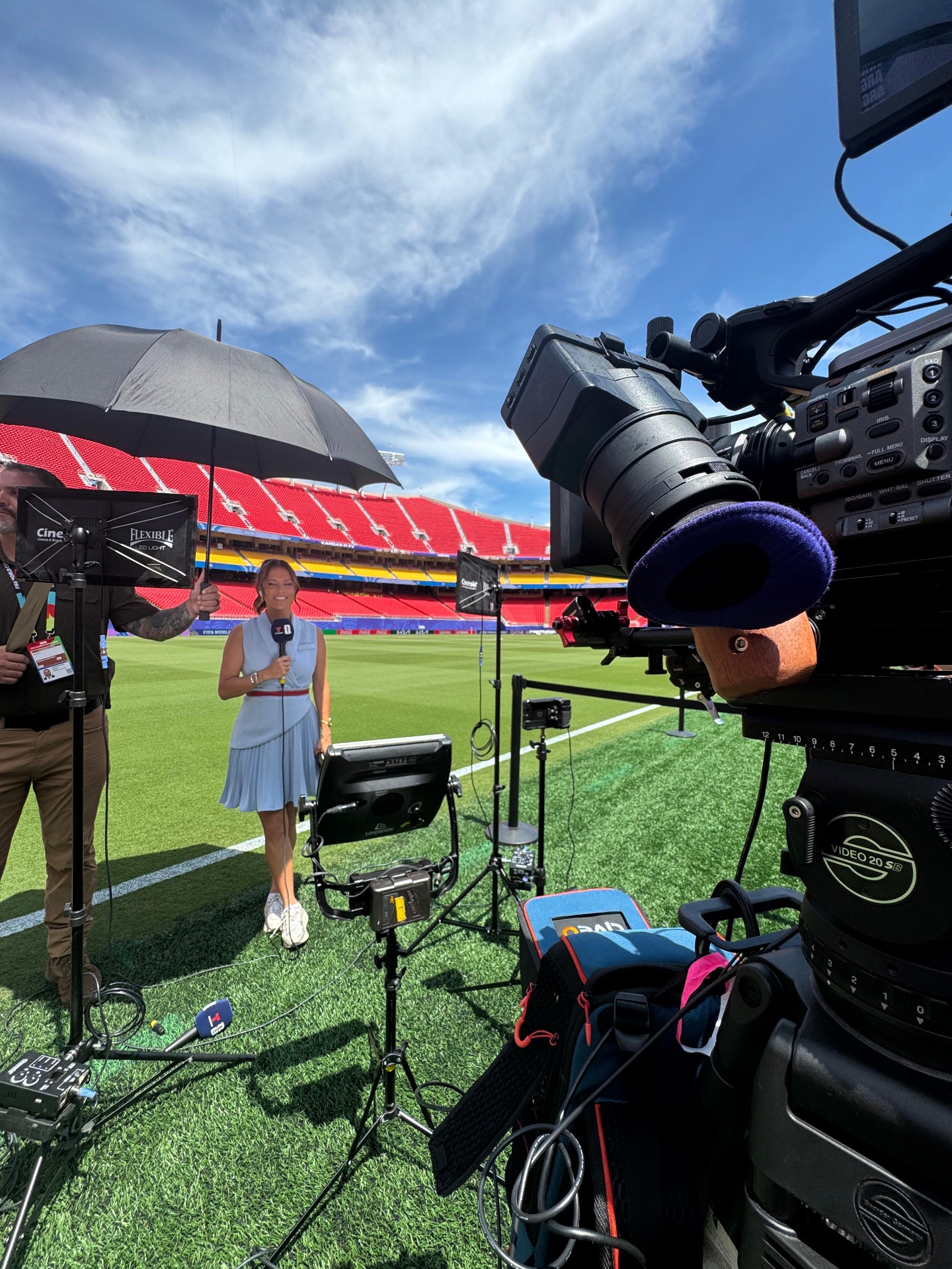 Reporter and broadcast camera covering a match at the stadium